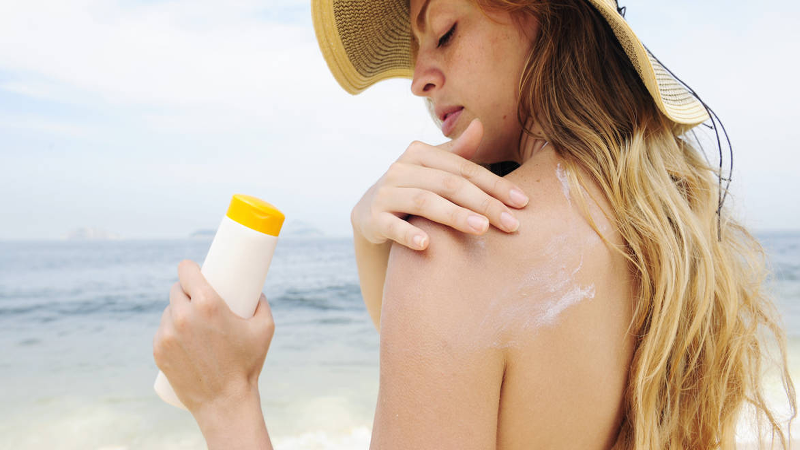 Можно ли загореть с кремом. Солнцезащитный крем на пляже. Девушка с солнцезащитным кремом. Солнцезащитные крема нанесение. Девушка мажется солнцезащитным кремом.